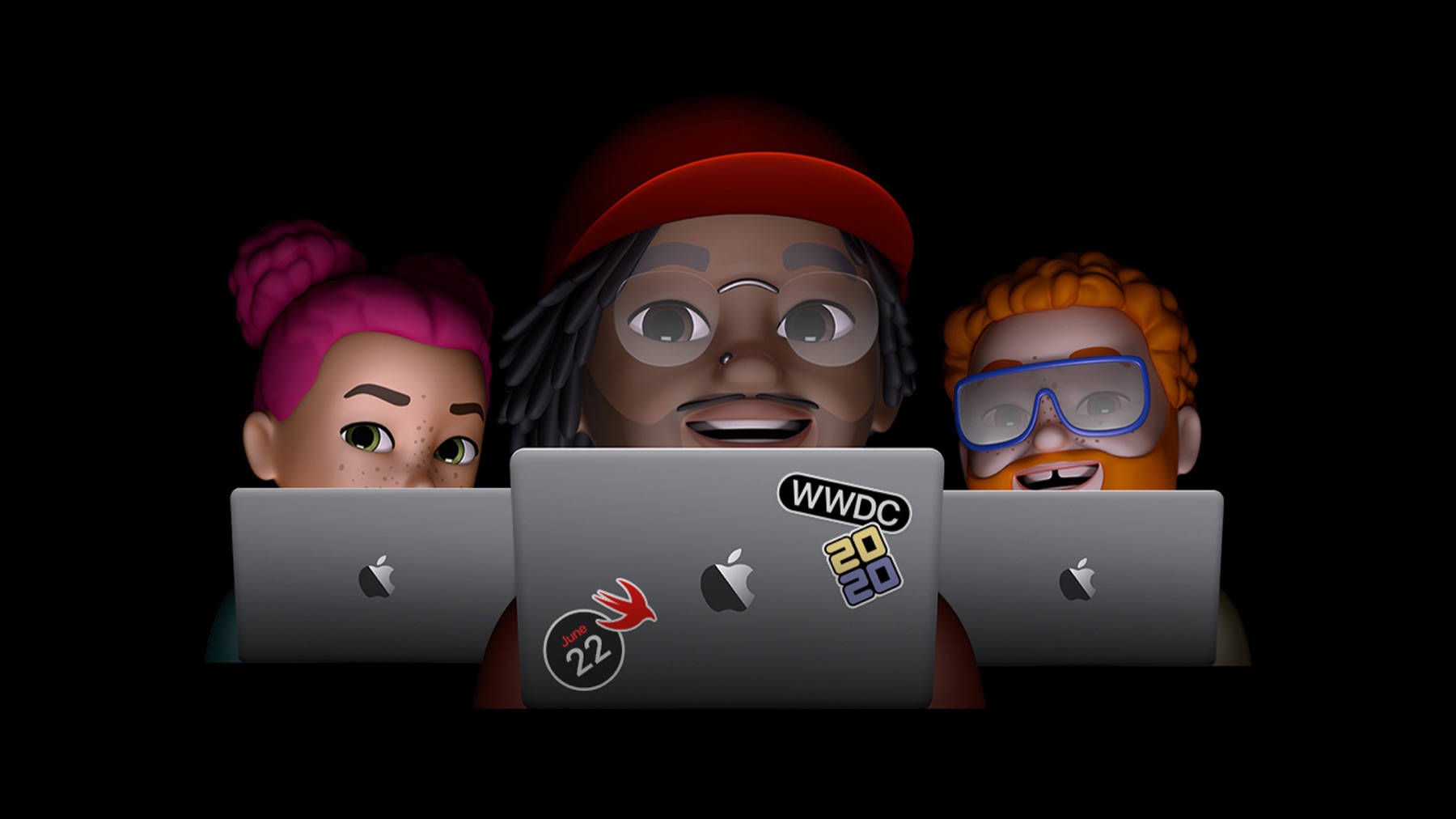 Three students at laptops in a dark studio